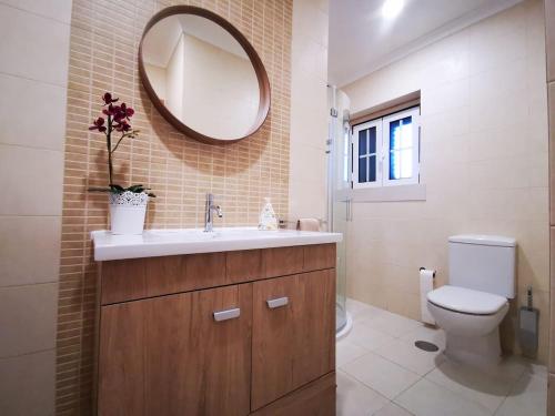 a bathroom with a sink and a toilet and a mirror at Casa com ALma in Fátima