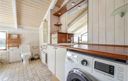 y baño con aseo y lavadora y secadora. en Nice Home In Knebel With Sauna, en Skødshoved Strand