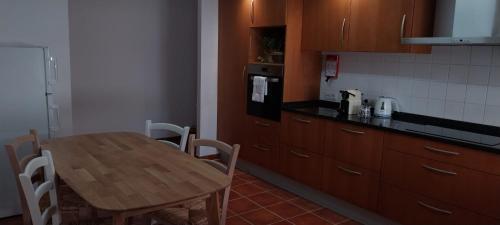 uma cozinha com uma mesa de madeira, uma mesa e cadeiras em Casa com ALma em Fátima