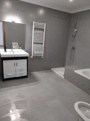 a bathroom with a sink and a toilet and a tub at Casa com Alma by LovelyStay in Fátima