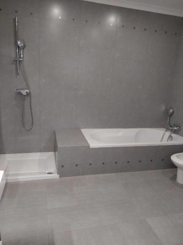 a bathroom with a bath tub and a toilet at Casa com Alma by LovelyStay in Fátima
