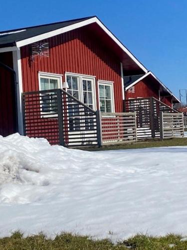 ein rotes Haus mit Schnee davor in der Unterkunft Mösseberg Camping in Falköping