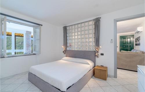 Castiglione ChiavareseにあるCasa Relax In Collinaの白いベッドルーム(ベッド1台、窓2つ付)