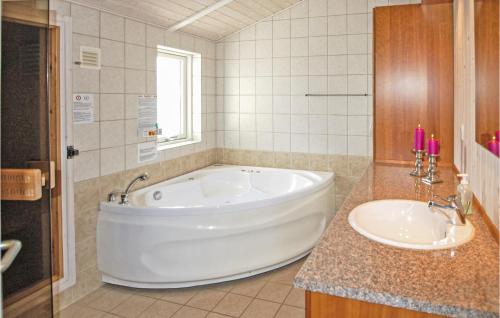 baño con bañera grande y lavamanos en 3 Bedroom Beautiful Home In Juelsminde, en Sønderby