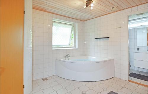 Awesome Home In Odder With Wifi في Odder: حوض أبيض في حمام مع نافذة