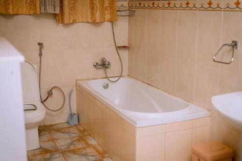 La salle de bains est pourvue d'une baignoire, de toilettes et d'un lavabo. dans l'établissement Emerald Villa, à Kigali