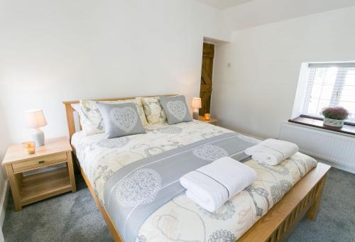 a bedroom with a large bed with two pillows at Tyddyn Waen in Llanddona