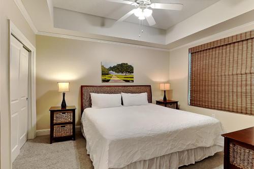 a bedroom with a bed with two night stands and two lamps at Wharf #506 in Orange Beach