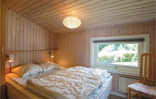 een slaapkamer met een bed in een kamer met een raam bij Lillebo in Brejning