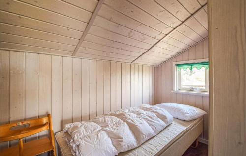 Bett in einem Zimmer mit einer Holzwand in der Unterkunft Lovely Home In Brkop With Kitchen in Brejning