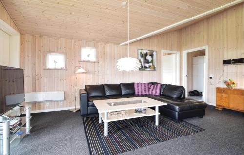 KrejbjergにあるAwesome Home In Ejstrupholm With 4 Bedrooms, Sauna And Wifiのリビングルーム(黒い革張りのソファ、テーブル付)