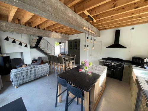 a kitchen with a table and a living room at Le Gite du Moulin de la Pisciculture de Monchel sur Canche in Conchy-sur-Canche