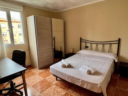 a bedroom with a bed with two towels on it at Bonito apartamento cerca de la playa in Valencia