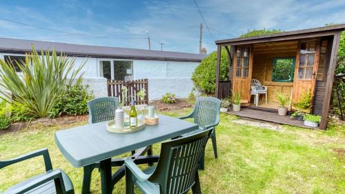 a table and chairs in a yard with a shed at Borth Bach in Rhosneigr