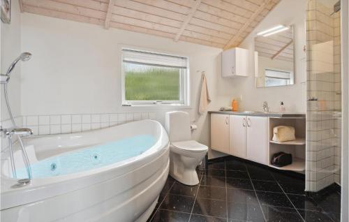 a bathroom with a tub and a toilet and a sink at Beautiful Home In Ebeltoft With 5 Bedrooms, Sauna And Wifi in Ebeltoft