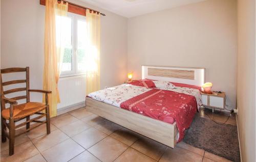 een slaapkamer met een bed, een stoel en een raam bij 3 Bedroom Beautiful Home In Montlimar in Montélimar