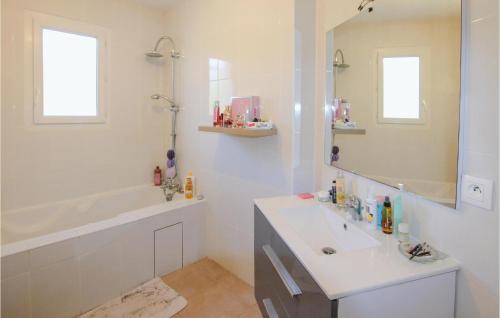 een badkamer met een wastafel, een bad en een spiegel bij 3 Bedroom Beautiful Home In Montlimar in Montélimar