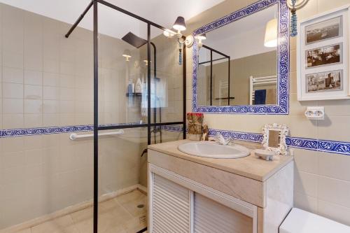 een badkamer met een wastafel, een douche en een spiegel bij Little Paradise 25 min from Lisbon in Azeitao