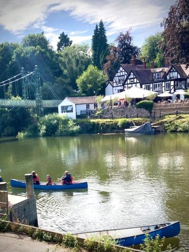 two people are in boats on a river at The Old Stables, The River Severn, Shrewsbury in Shrewsbury