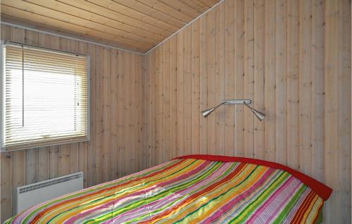 KnebelにあるAwesome Home In Knebel With Sauna And 2 Bedroomsのベッドルーム1室(カラフルな毛布付きのベッド1台付)