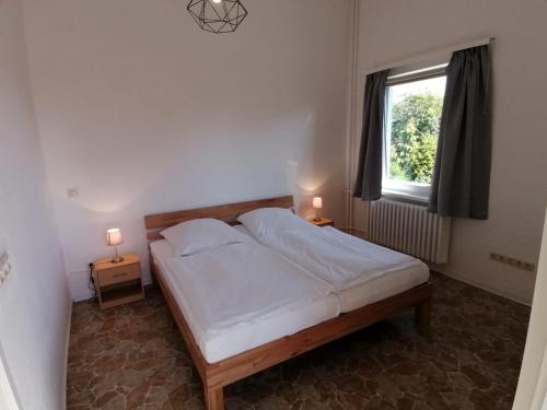 1 dormitorio con 1 cama, 1 ventana y 2 lámparas en Pension Sonnenhof en Braunlage