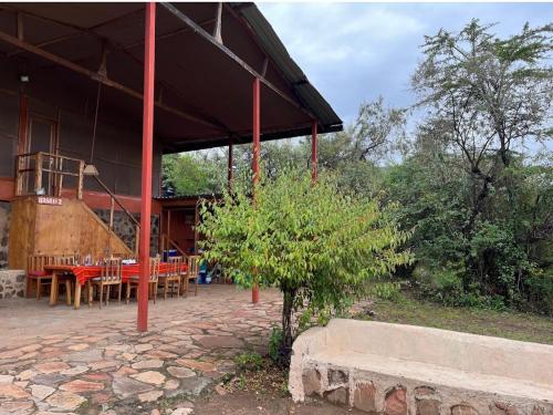 a house with a table and chairs in front of it at Mara Moon cottages in Sekenani