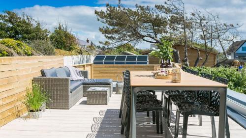 a patio with a wooden table and chairs at Brig y Don in Rhosneigr
