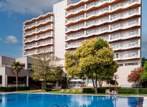 un edificio con piscina frente a un edificio en Hotel Medium Valencia en Valencia