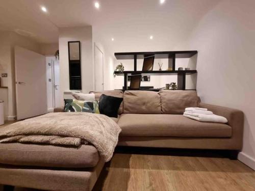 una sala de estar con un sofá marrón en una habitación en Charming studio in Bricklane en Londres