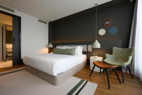 um quarto com uma cama, uma cadeira e uma mesa em NEO KVL Hotel by TASIGO em Oisterwijk