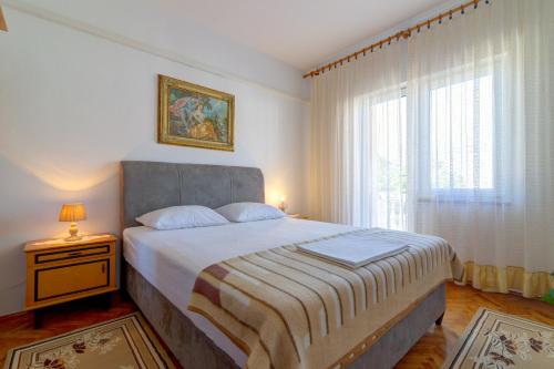 a bedroom with a large bed and a window at Apartman Erika in Senj