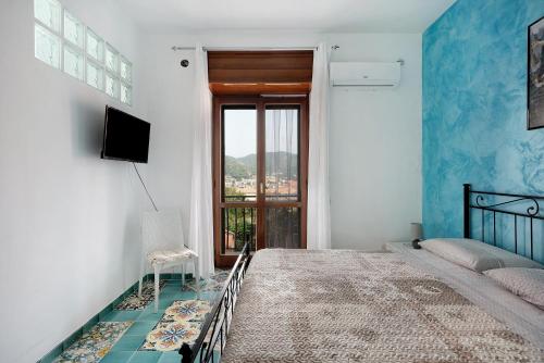 a bedroom with a bed and a television and a window at Appartamento Menelao in Cava deʼ Tirreni