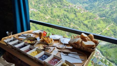 a table with bread and other food on it with a view at Vaveyladağevleri in Çamlıhemşin
