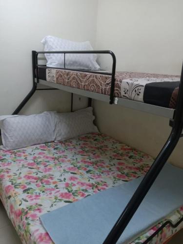 甘孟的住宿－NORIS GUEST HOUSE 2，配有花毯的客房内的2张双层床