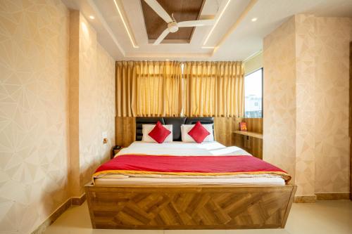 ein Schlafzimmer mit einem großen Bett mit roten Kissen in der Unterkunft Seasons Suites - Koramangala in Bangalore