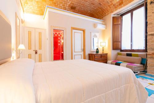 a bedroom with a large white bed and a brick wall at Residenza Sveva in Termoli