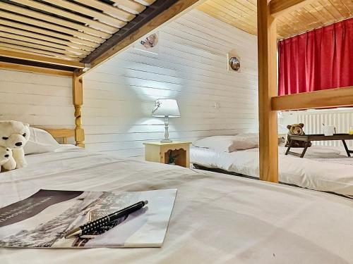 - une chambre avec deux lits et un ours en peluche dans l'établissement Tignes Le Lac - Appt cosy 32m², 4 pers, Pied des pistes, Sud-Est, Animaux OK, Équipé & Fonctionnel - FR-1-411-149, à Tignes