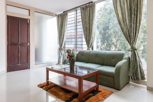 ein Wohnzimmer mit einem Sofa und einem Couchtisch in der Unterkunft Seasons Suites - Koramangala in Bangalore