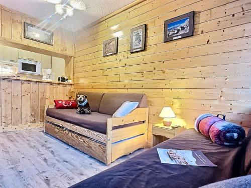 une chambre avec un canapé et un chien assis sur une chaise dans l'établissement Charmant studio 4 pers. à Tignes Val Claret, pied des pistes, balcon sud, proche commerces - FR-1-411-462, à Tignes