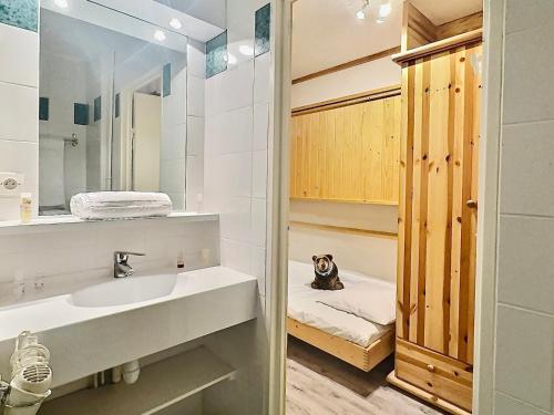 un chien assis sur un lit dans une salle de bains dans l'établissement Charmant studio 4 pers. à Tignes Val Claret, pied des pistes, balcon sud, proche commerces - FR-1-411-462, à Tignes