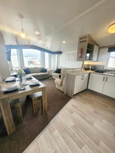 a kitchen and living room with a table and a couch at Golden Palm Getaway's PG143 in Skegness