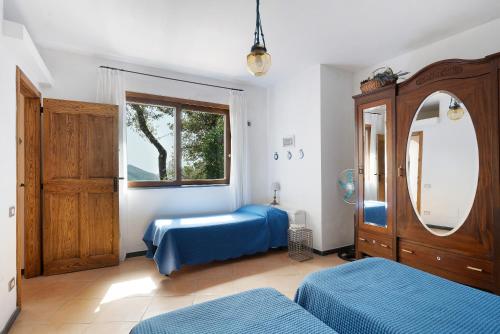 a bedroom with two beds and a mirror and a window at Dependance in Costiera Amalfitana in Cava deʼ Tirreni