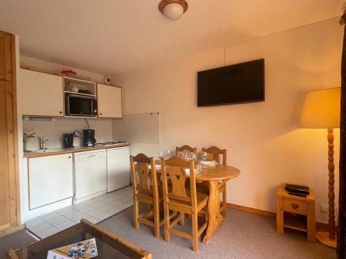 une cuisine et une salle à manger avec une table et des chaises dans l'établissement Appartement 2 pièces avec Piscine, WiFi et Garage à Méribel Centre - FR-1-411-654, à Les Allues