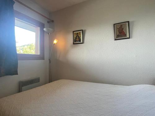 une chambre avec un lit et deux tableaux au mur dans l'établissement Appartement 2 pièces avec Piscine, WiFi et Garage à Méribel Centre - FR-1-411-654, à Les Allues
