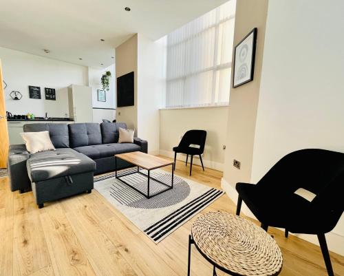 a living room with a blue couch and chairs at Bright and Spacious 2 bed apt - sleeps up to 6 in Manchester