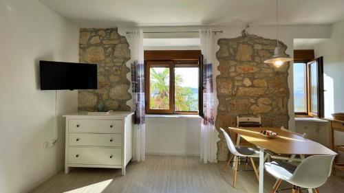 ein Wohnzimmer mit einem Tisch, einem TV und einem Fenster in der Unterkunft Apartments Gorisek in Šilo