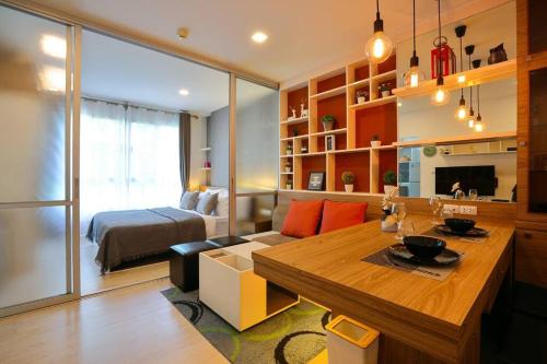 a living room with a table and a bedroom at Greenery living in resort condo in Chiang Mai