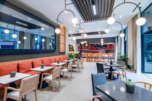an empty restaurant with tables and chairs at NEO KVL Hotel by TASIGO in Oisterwijk
