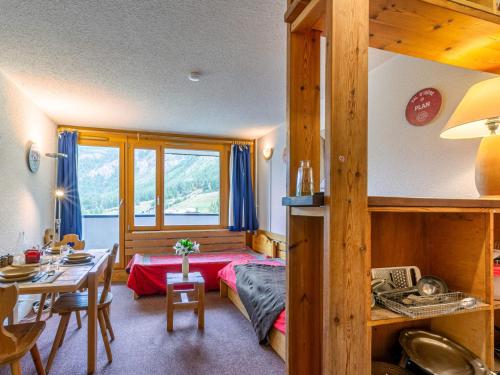 une chambre avec un lit et une table et une salle à manger dans l'établissement Studio sud au pied des pistes, balcon et animaux acceptés - FR-1-694-209, à Val dʼIsère