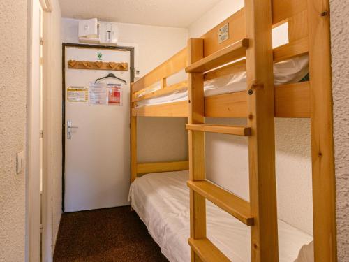 Cette chambre dispose de lits superposés, d'un réfrigérateur et d'une porte. dans l'établissement Studio sud au pied des pistes, balcon et animaux acceptés - FR-1-694-209, à Val dʼIsère